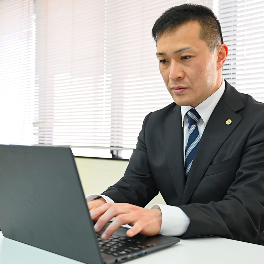 真剣な顔でキーボードを打つ男性